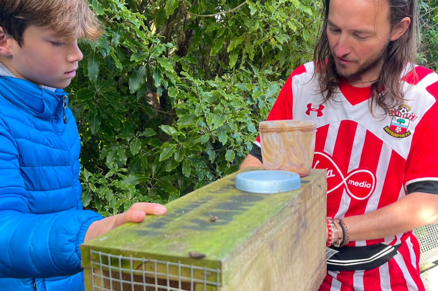 Phil Wisker demonstrates how to bait and set a rat trap for Charlie Kettle, who walks a trapline as part of his volunteering work towards a Duke of Edinburgh Bronze Award.